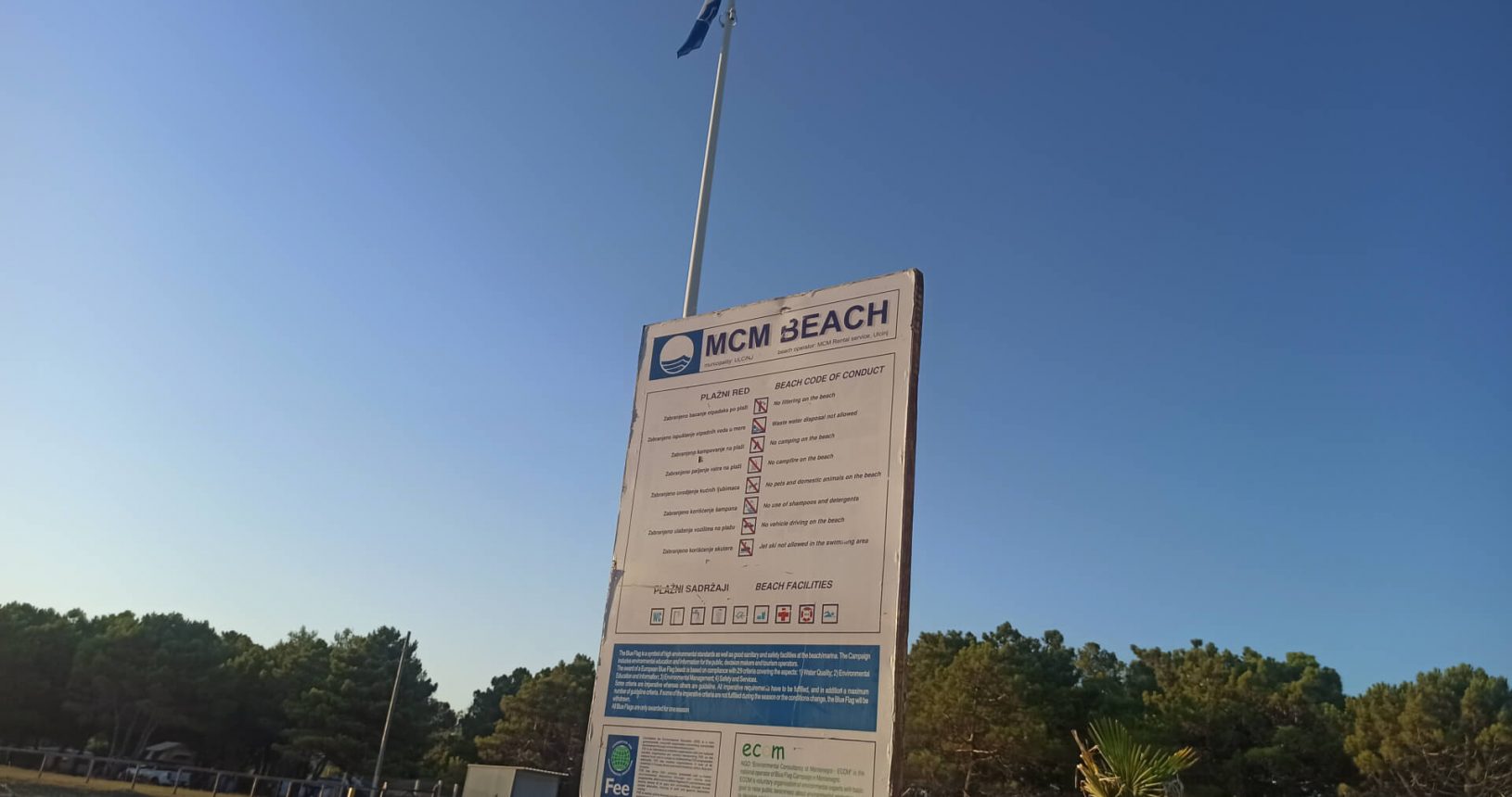 MCM Beach sign and blue flag