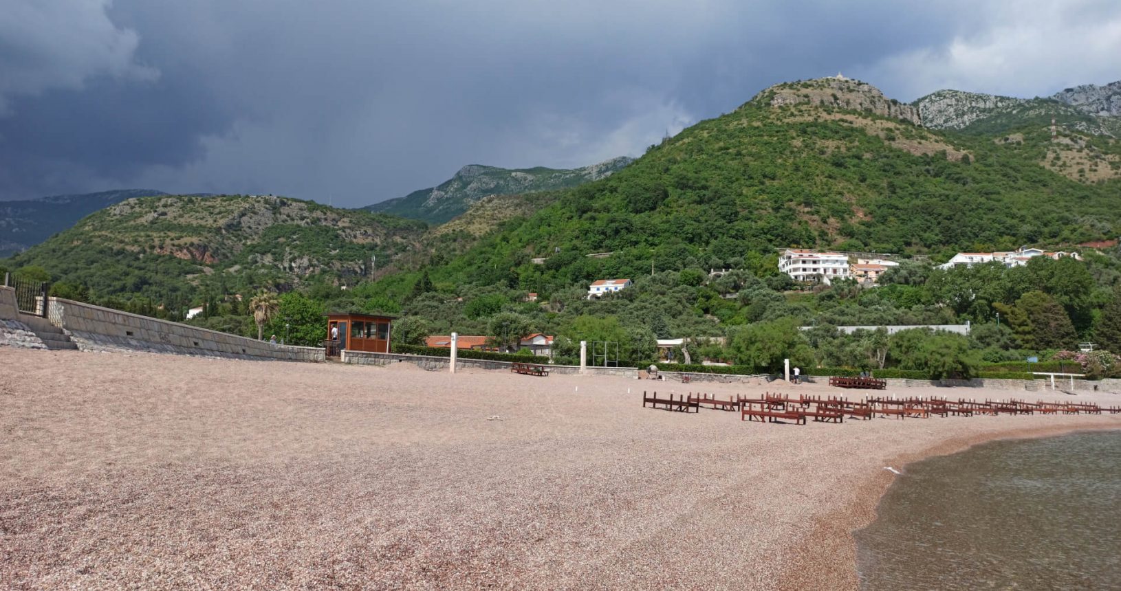 Empty sandy Sveti Stefan beach. Mountains view