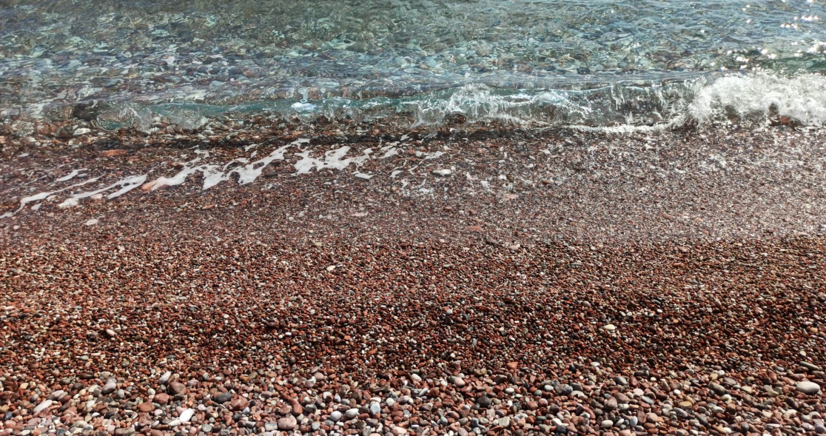 Transparent sea and red stones. Sveti Stefan beach