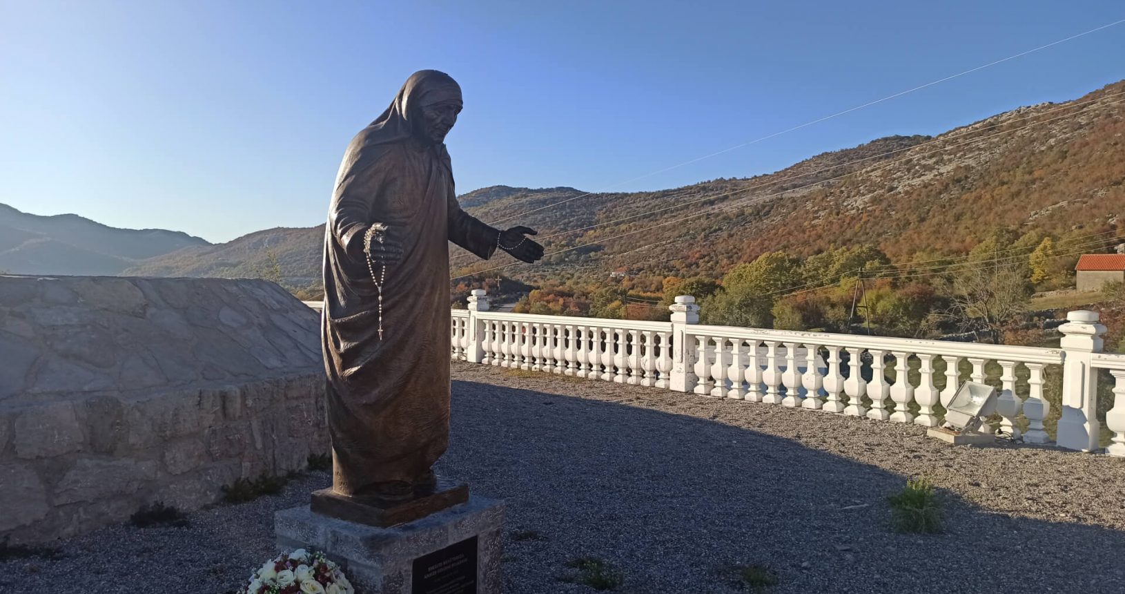 Mother Teresa in front of the valley Viewpoint with big cross and Jesus