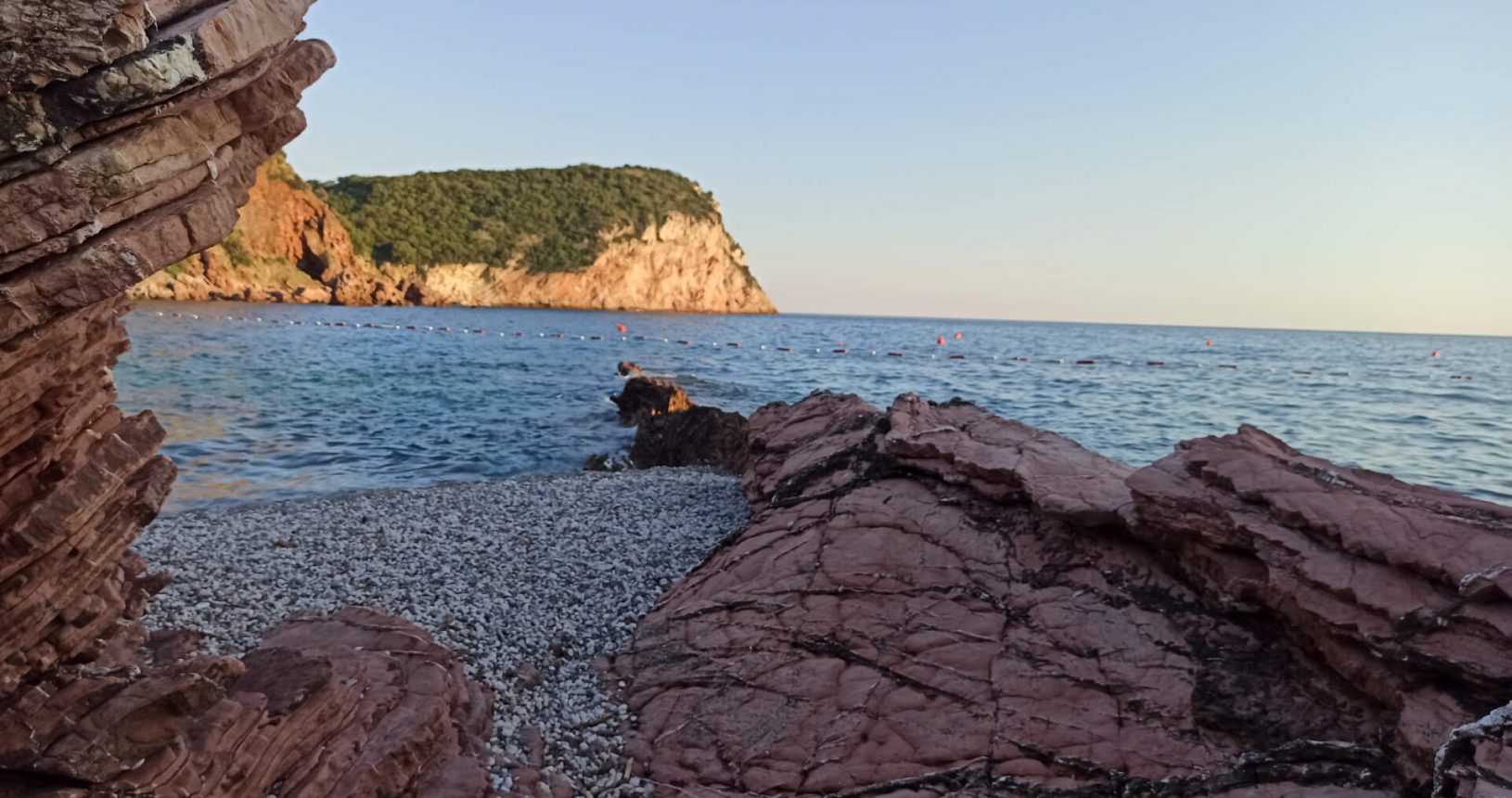 Lovely beach from behind red rocks Crvena Glavica Beach